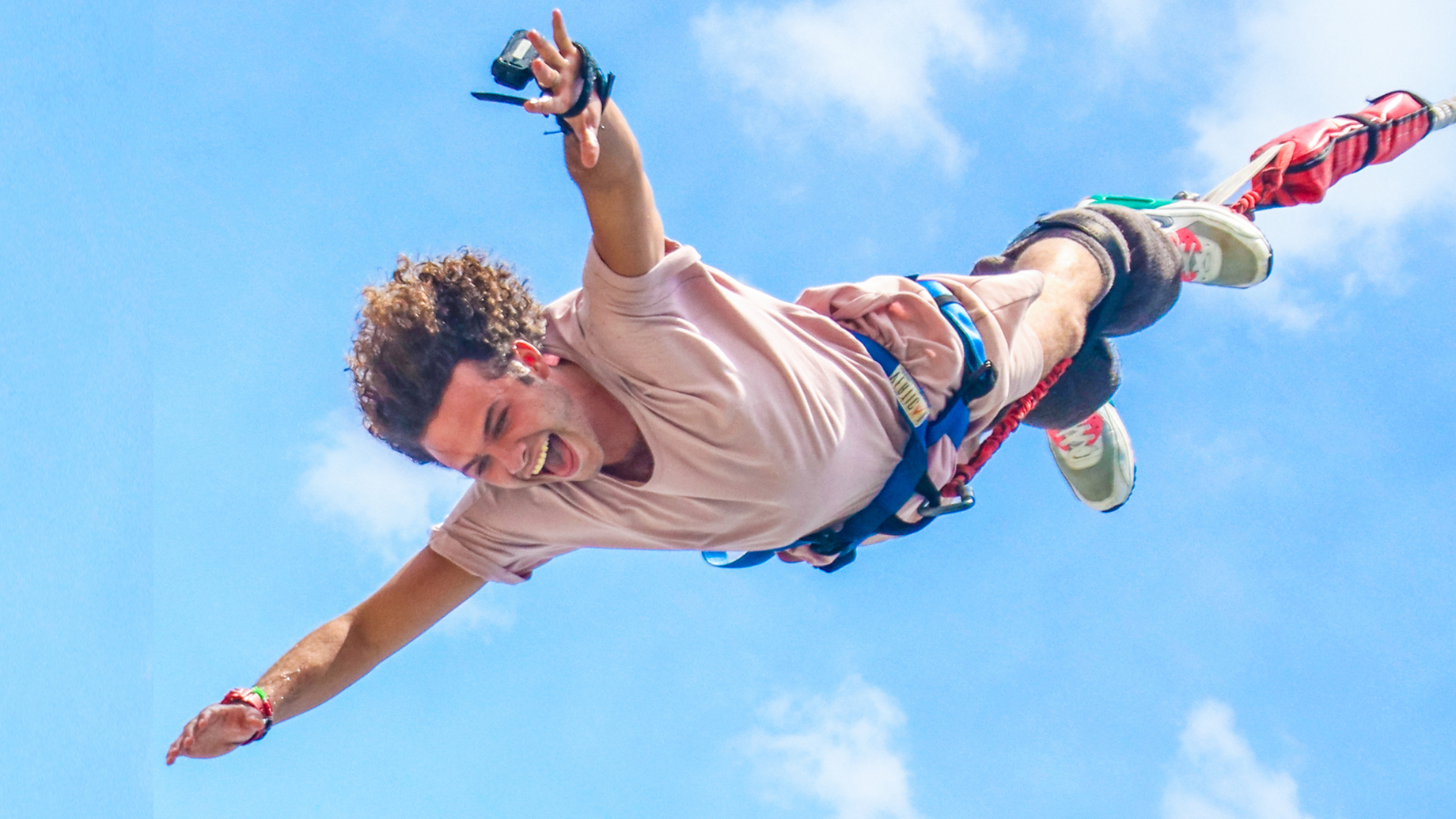 A man with a GoPro strapped on his hand doing the bungy jump at AJ Hackett