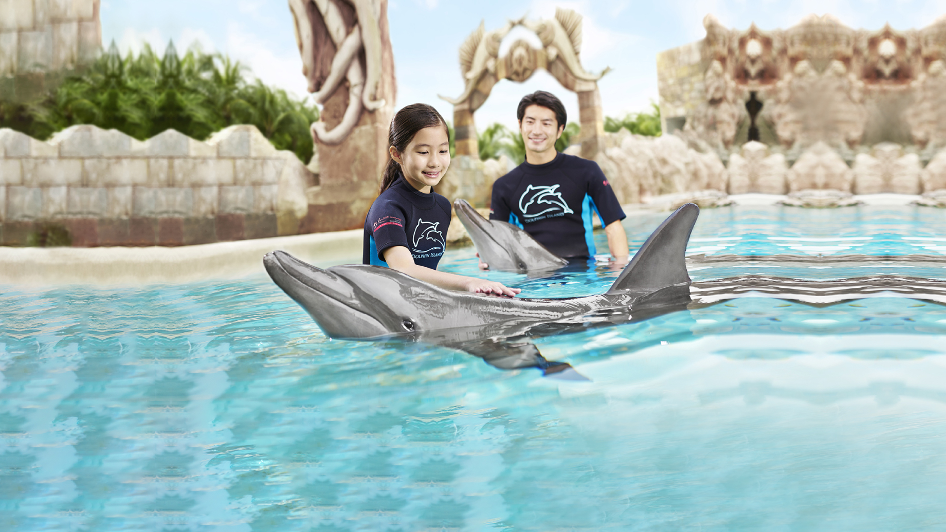 A young girl coming face-to-face with a gentle and playful bottlenose dolphin
